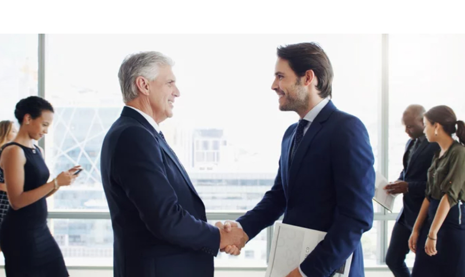 A photo of smiling businessmen shaking hands